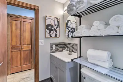a bathroom with a sink and a shelf with towels at Deck and Fenced Yard Capitol Hill Townhome in Denver