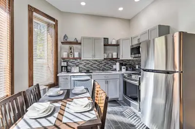 a kitchen with a table and a refrigerator at Less Than 1 Mi to St Josephs Denver Townhome! in Denver