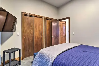 a bedroom with a blue bed and wooden cabinets at Less Than 1 Mi to St Josephs Denver Townhome! in Denver