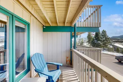 a blue rocking chair sitting on the porch of a house at Winter Park Lodge II #104 in Fraser