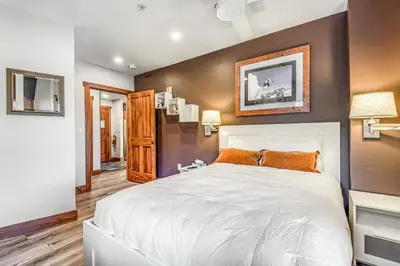 a bedroom with a large white bed and brown walls at Red Hawk 2276 in Keystone