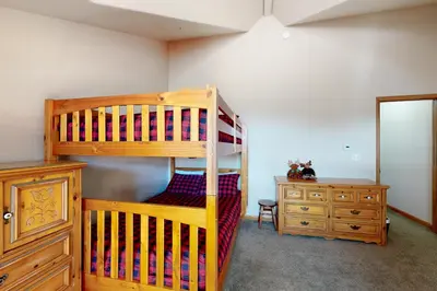 a bedroom with a wooden bunk bed and a dresser at Wish Upon a Morningstar in Frisco