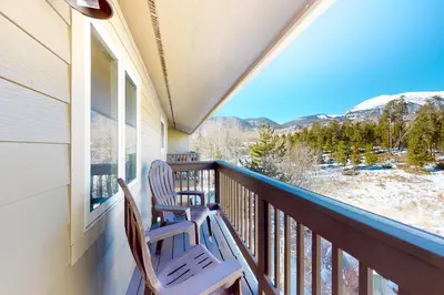two chairs sitting on a balcony looking out at the mountains at Wish Upon a Morningstar in Frisco