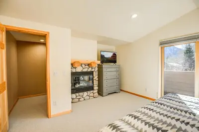 a bedroom with a bed and a fireplace at Crossroads Nordic Townhome: Spacious, On Bike Path in Frisco
