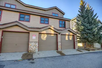 a house with two garage doors and a tree at Crossroads Nordic Townhome: Spacious, On Bike Path in Frisco