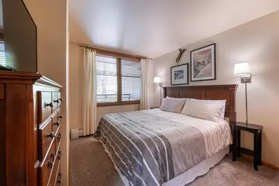 a bedroom with a bed and a dresser and a window at Zephyr Mountain Lodge Premium-Rated 2108 in Winter Park