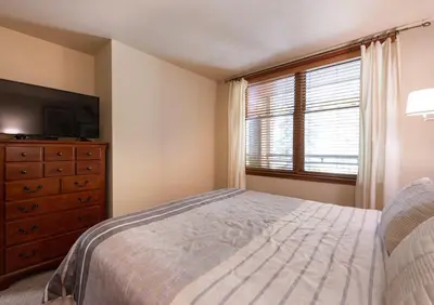 a bedroom with a bed and a dresser and a window at Zephyr Mountain Lodge Premium-Rated 2108 in Winter Park