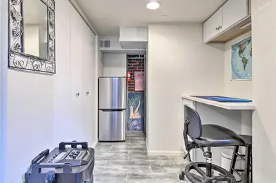 a kitchen with a chair and a refrigerator at Steps to City Park and Restaurants Denver Studio in Denver