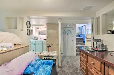 a bedroom with a bed and a kitchen with a sink at Steps to City Park and Restaurants Denver Studio in Denver
