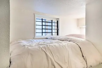 a white bed in a room with a window at Steps to City Park and Restaurants Denver Studio in Denver