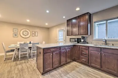 a kitchen with wooden cabinets and a dining room at Walk to Broncos Stadium Modern Denver Duplex in Denver