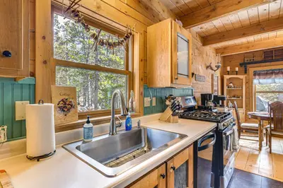 a kitchen with a sink and a stove at Deck, Fire Pit and Grill Log Cabin in Black Hawk in Black Hawk