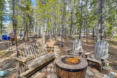 two chairs and a fire pit in the woods at Deck, Fire Pit and Grill Log Cabin in Black Hawk in Black Hawk