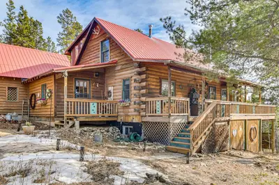 a log cabin with a red roof and a deck at Deck, Fire Pit and Grill Log Cabin in Black Hawk in Black Hawk
