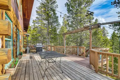 a deck with a table and chairs on it at Deck, Fire Pit and Grill Log Cabin in Black Hawk in Black Hawk