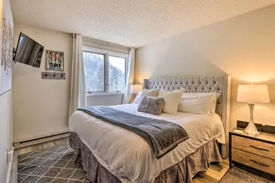 a bedroom with a large bed and a window at Ski-InandSki-Out Winter Park Condo with Balcony! in Winter Park