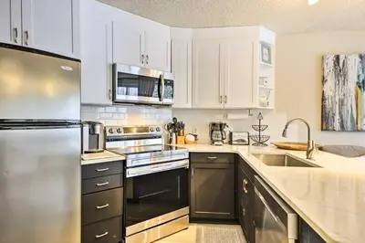 a kitchen with white cabinets and stainless steel appliances at Ski-InandSki-Out Winter Park Condo with Balcony! in Winter Park