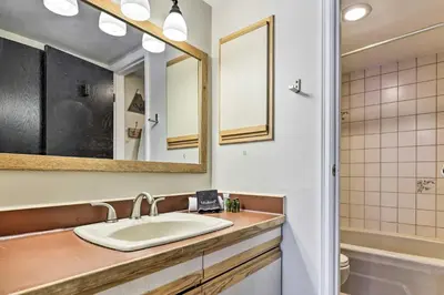a bathroom with a sink and a mirror and a tub at Ski-InandSki-Out Winter Park Condo with Balcony! in Winter Park