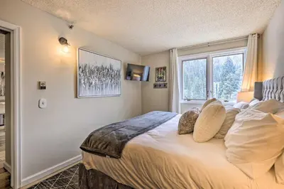 a bedroom with a large bed and a window at Ski-InandSki-Out Winter Park Condo with Balcony! in Winter Park