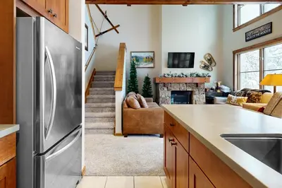 a kitchen and living room with a stainless steel refrigerator at Knocking at Nature's Door in Keystone