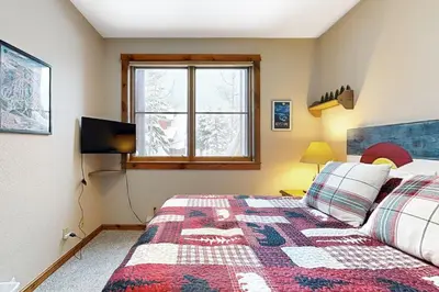 a bedroom with a bed and a tv and a window at Knocking at Nature's Door in Keystone