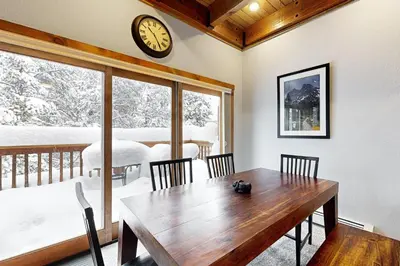 a dining room with a table and a clock on the wall at Knocking at Nature's Door in Keystone