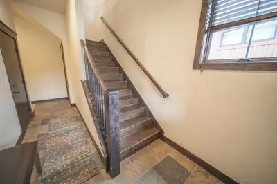 a wooden staircase in a room with a window at Alders 42 Outpost Dr by SummitCove Lodging in Keystone