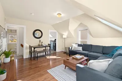 a living room with a blue couch and a table at Cozy Victorian Cottage in the Heart of Old Town! in Fort Collins