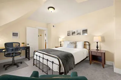a bedroom with a bed and a desk and a chair at Cozy Victorian Cottage in the Heart of Old Town! in Fort Collins