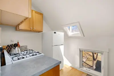 a kitchen with a stove and a white refrigerator at Cozy Victorian Cottage in the Heart of Old Town! in Fort Collins
