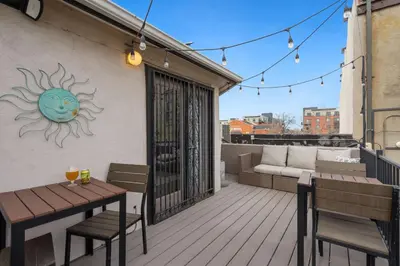 a patio with a table and chairs on a balcony at Pine Street Loft Steps from Old Town Square in Fort Collins