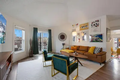 a living room with a couch and a table at Pine Street Loft Steps from Old Town Square in Fort Collins