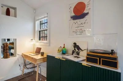 a kitchen with a green cabinet and a desk at Pine Street Loft Steps from Old Town Square in Fort Collins