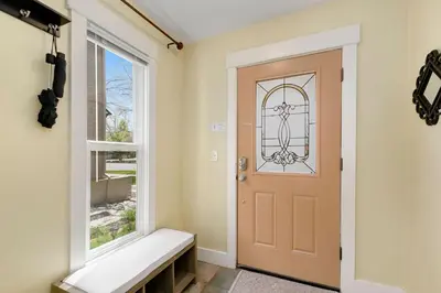 a door in a room with a bench next to a window at Walk Everywhere - Art, Restaurants, Poudre River in Fort Collins