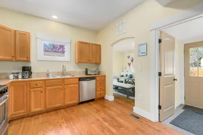 a kitchen with wooden cabinets and a sink at Walk Everywhere - Art, Restaurants, Poudre River in Fort Collins