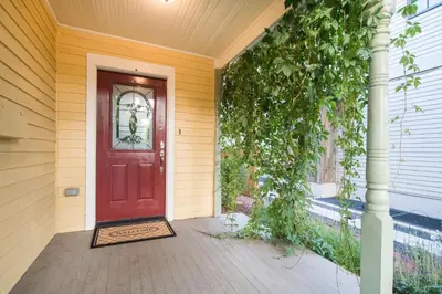 a red door on a house with a porch at Walk Everywhere - Art, Restaurants, Poudre River in Fort Collins