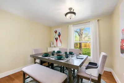 a dining room with a table and chairs and a window at Walk Everywhere - Art, Restaurants, Poudre River in Fort Collins