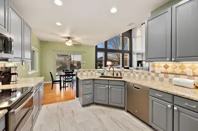 a kitchen with gray cabinets and a dining room at Family-friendly Home on Boyd Lake, Gorgeous Views! in Loveland