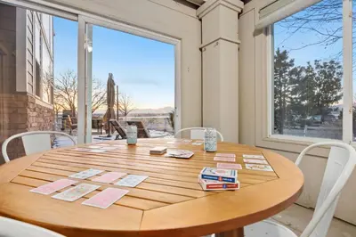 a wooden table with white chairs and a large window at Family-friendly Home on Boyd Lake, Gorgeous Views! in Loveland