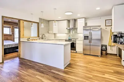 a kitchen with white cabinets and a refrigerator at 7 Mi to Skiing! Mtn-View Hot Tub Haven in Frisco in Frisco