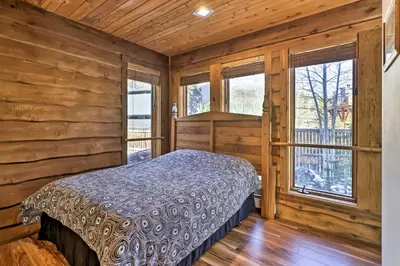 a bedroom with a bed in a wooden room with windows at 7 Mi to Skiing! Mtn-View Hot Tub Haven in Frisco in Frisco
