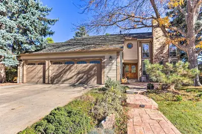 a house with a garage with a driveway at Near Shops and Eats! Centennial Escape with Sunroom in Centennial