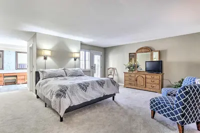 a bedroom with a bed and a tv and a chair at Near Shops and Eats! Centennial Escape with Sunroom in Centennial
