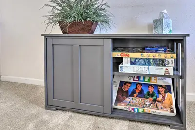 a tv stand with a display of magazines at Near Shops and Eats! Centennial Escape with Sunroom in Centennial
