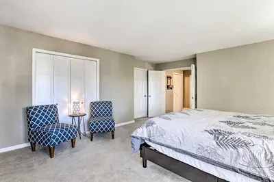 a bedroom with a bed and two chairs and a table at Near Shops and Eats! Centennial Escape with Sunroom in Centennial