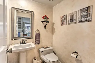 a bathroom with a sink and a toilet and a mirror at Near Shops and Eats! Centennial Escape with Sunroom in Centennial