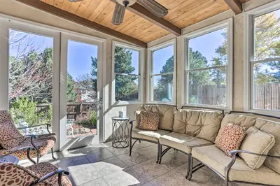 a screened porch with a couch and windows at Near Shops and Eats! Centennial Escape with Sunroom in Centennial