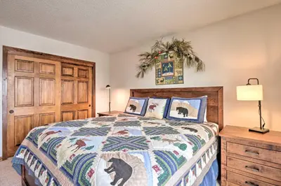 a bedroom with a bed and a wooden door at Ski, Hike and Explore All-Season Frisco Condo in Frisco