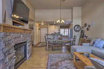 a living room with a fireplace and a dining room at Gorgeous Fraser Townhome with Private Hot Tub! in Fraser