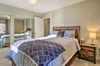 a bedroom with a large bed with a wooden headboard at 4 Mi to Keystone Resort Dillon Condo with Patio in Dillon